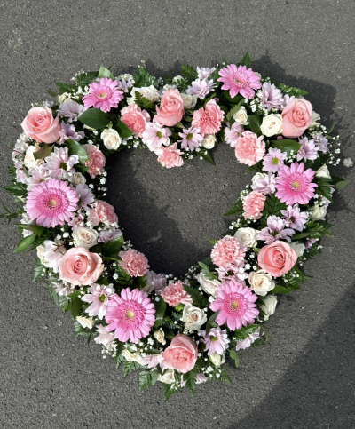 Pink heart funeral tribute - A heart tribute in pinks and whites with a mix of flowers
