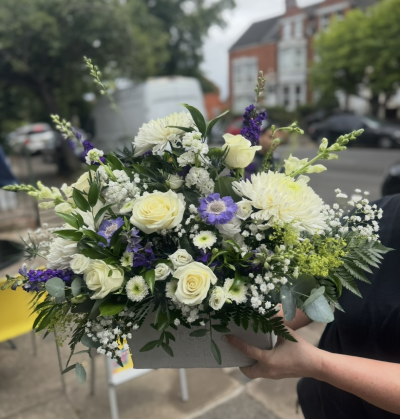 White and blue arrangement - An arrangement in a white planter with a mix of white and blue flowers